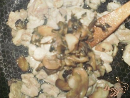 К мясу добавляем нарезанные грибы и жарим пока не испарится жидкость от грибов.