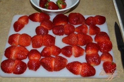 Клубнику порезать на половинки,можно оставить несколько цельных ягод для украшения сверху торта.