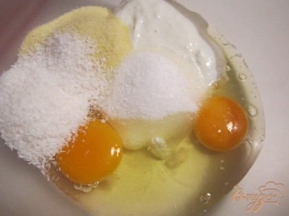 Яйца, творог, сахар, манку и кокосовую стружку смешать .