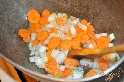 Лук нарезать кубиками, морковь нарезать кружочками или брусочками.В казанке или гусятнице разогреть растительное масло и обжарить овощи до слегка золотистого цвета.
