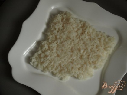 Из варёного риса выложить на тарелке ракушку.