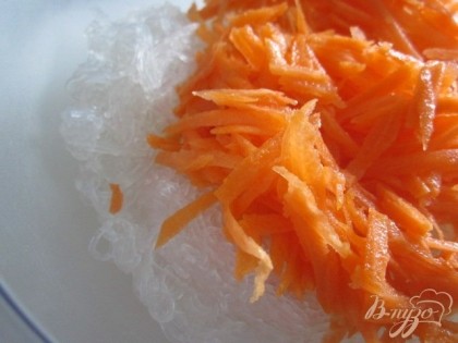 Морковь натереть на крупной терке, немного полить соком лимона и помять рукой. Выложить к лапше.