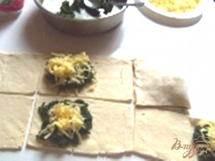 Разрезаем тесто на квадратики, выкладываем в каждый шпинат и сверху горочку сыра.