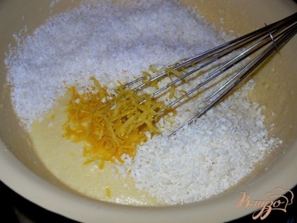 Добавить в масляно-яичной массе кокосовую стружку, тертый белый шоколад, измельченную цедру лимона и щепотку соли. Хорошо вымешать.