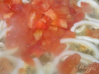 Кольца кальмаров и томаты обжарить в большой сковороде, посолить, всыпать базилик, чеснок, пропущенный через пресс и готовить 5 минут.
