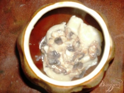 В горшочек слоями выложить пельмени и грибы со сметаной.