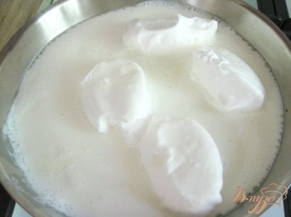 Используя две столовые ложки, сформировать из смеси шарики в виде яйца. Налить в сковороду молоко и доведите до кипения. Опустить шарики в кипящее молоко, через 30-40 сек. когда шарики увеличатся, перевернуть на другую сторону.