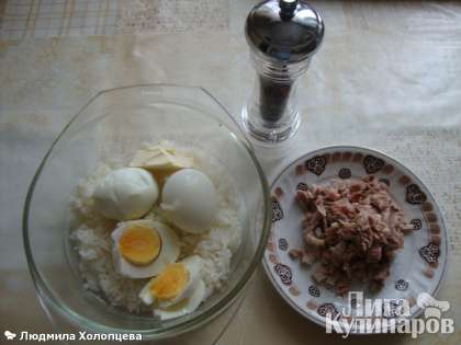 Отвариваем рис и яйца.В откинутый рис рубим вареные яйца, добавляем мелко нарезанное куриное мясо из бульона, масло, солим, перчим.