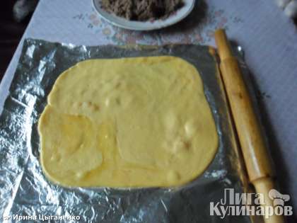 На разделочную доску постелить фольгу, затем выложить сыр и раскатать скалкой в пласт толщиной примерно 0,5 см