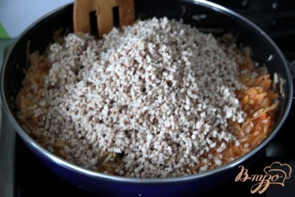 Под конец добавляем прокрученное вареное мясо сверху. Добавить немного воды, перемешать и тушить до полной готовности риса.