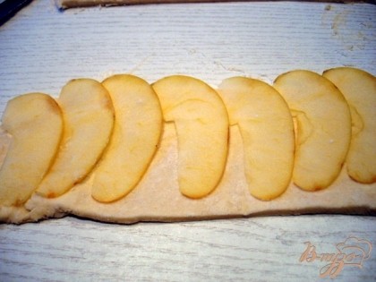На полоски разложить яблоки, так, чтобы они на 2-3 миллиметра высовывались наружу.