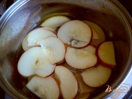 Из воды и сахара сварить сироп. 2 яблока для украшения помыть и порезать тонкими пластинка, не очищая от кожицы. Положить в горячий сироп, довести до кипения и выложить на сито, охладить.