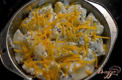 Картофель чищенный отварить,уложить на сковороду или в форму,помазать оставшейся сметаной, посыпать тертым сыром и обжарить в духовке до золотистой корочки.