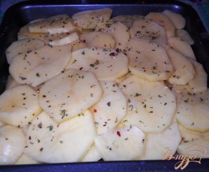 Картофель чистим, моем и режем тонкими кольцами. Выкладываем в форму чешуйками на мясо. Немного солим и посыпаем травами или приправой для картофеля.