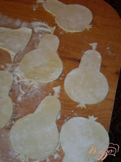 Теперь немного раскатаем размороженное бездрожжевое тесто и с помощью шаблона вырезаем груши.
