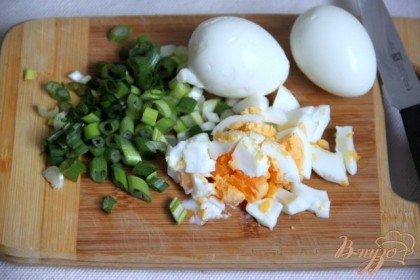 Нарезать вареные яйца и зелёный лук.