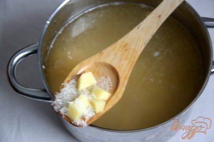 Параллельно готовим суп-основу. В разогретую воду с рыбным бульоном (3 литра) добавить картофель, нарезанный маленькими кубиками и промытый рис. Варить до готовности