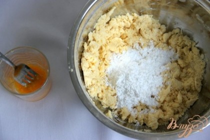 Просеянную муку порубить ножом со сливочным маслом в крошку, добавить сахарную пудру, перемешать. Желтки двух яиц разболтать вилкой с ванильным сахаром.
