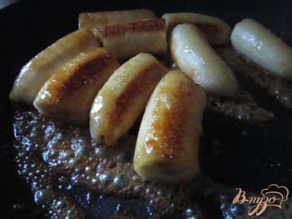Выложить кусочки банана на сковороду с растаявшим сахаром, обжарить с обеих сторон до румянца. Они должны покрыться тонким слоем карамели. В самом конце полить соком лимона.