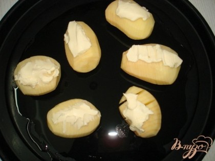 Картофель уложить на противень смазанный растительным маслом, разрезами вверх. На каждую картофелину положить кусочек сливочного масла.Запекать в духовке 45 минут.