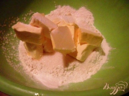 Муку просеять с разрыхлителем. Добавить размягчённый маргарин, сахар и замесить тесто.
