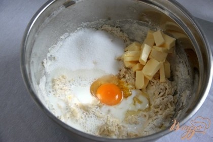 Добавить к муке сахар, натёртую цедру лимона, яйцо, оставшееся молоко и кусочки размягчённого сливочного масла.