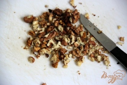 Очистить и нарезать небольшими кусочками грецкие  орехи. Добавить их в салат.