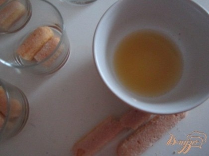 Из 1 мандарина выжать сок и пропитать им печенье. Уложить на дно стаканчиков (креманок)
