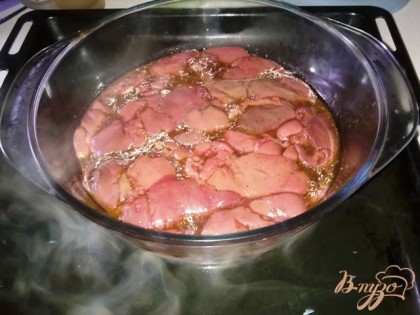 Переложить печенку в жаропрочную форму, накрыть фольгой и поставить в поддон с горячей водой. Перенести поддон в разогретую до 160 С духовку и готовить около 1 часа