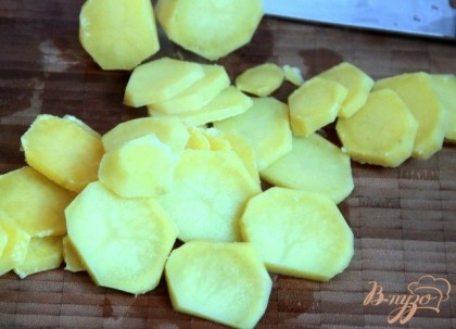 Воду слить через дуршлаг, картофель слегка остудить, чтобы был не очень горячим при нарезке.Картофель нарезать тонкими пластинками.