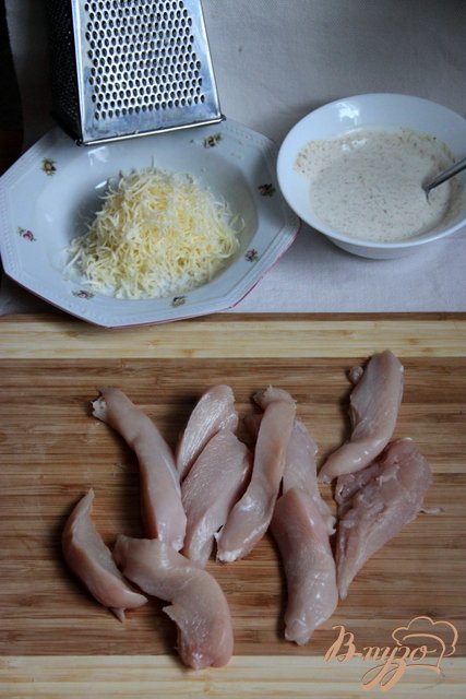 Куриное филе порезать на длинные брусочки шириной 2 см.Сметану смешать с горчицей и специями.Сыр натереть на мелкой тёрке. Смешать с кунжутом.