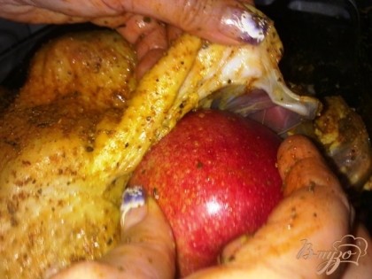 Разрезаем яблоки по полам и вкладываем внутрь гуся.