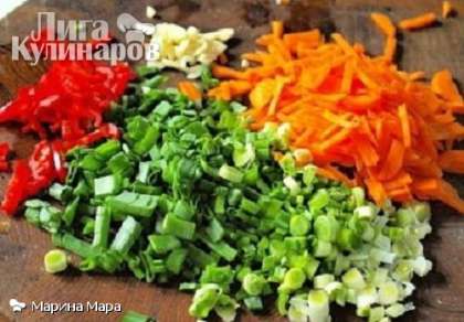 Мелко нарезать зеленый лук, перец чили (предварительно удалив семена и перегородки), чеснок и морковку.