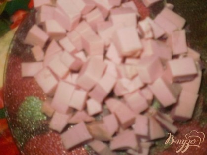 Колбасу нарезаем кубиками и отправляем к картофелю. Туда же добавляем мелко нарезанные огурцы и лук, солим, перчим.