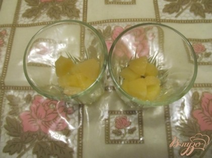 Выложить в стаканы нарезанные кусочками консервированные ананасы.
