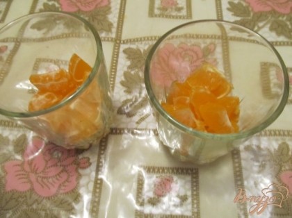 Нарезать мандарины, выложить в стаканы вторым слоем.