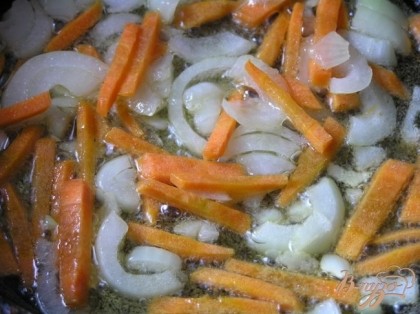 На растительном масле обжарить нарезанный лук и морковь,