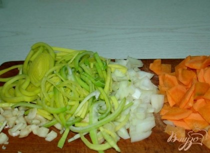 Нарезаем морковь, лук репчатый и лук порей и также опускаем в бульон.Следом за ними следует зелёный горошек.