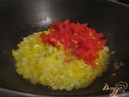 В глубокой сковороде на оливковом масле поджарить до золотистого цвета нарезанный мелко лук и перец. Добавить помидор, порезанный мелко. Накрыть крышкой и оставить потушиться минут 5.