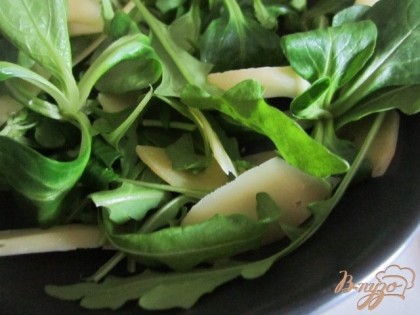 В тарелку выложить салатные листья и сыр.