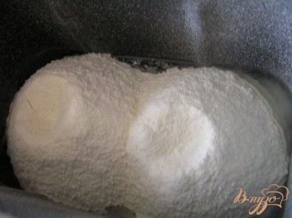 В контейнер хлебопечки налить воду, добавить соль и сахар. Всыпать муку,