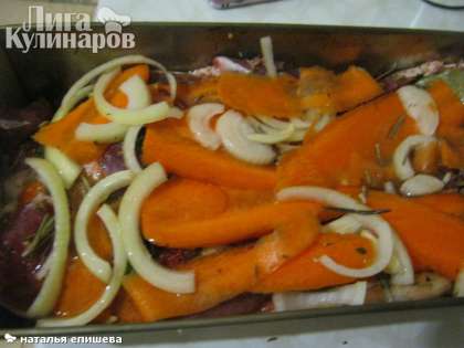 Говядину выкладываем в форму для запекания, сверху на мясо укладываем морковь, лук, чеснок и веточки розмарина