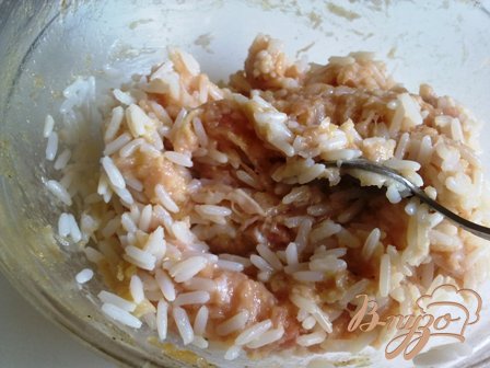 Добавляем остывший рис к фаршу, солим и перчим по вкусу.
