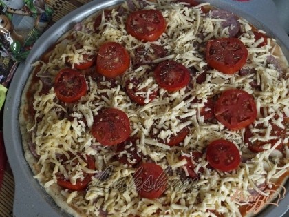 Первый слой пиццы посыпаем сыром и выкладываем ещё немного томатов сверху.