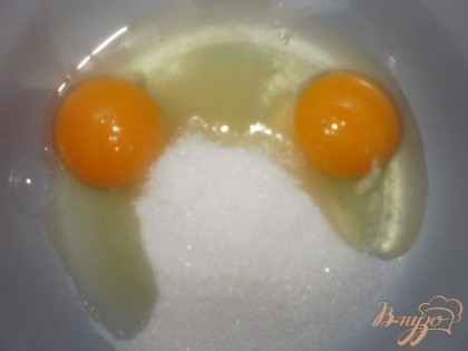 В глубокую посуду насыпаем сахар и разбиваем яйца.