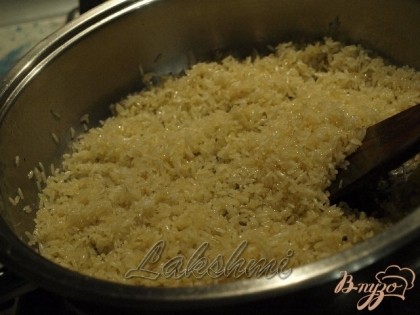 Мешать рис пока он хорошо промаслится и станет слегка золотистым.