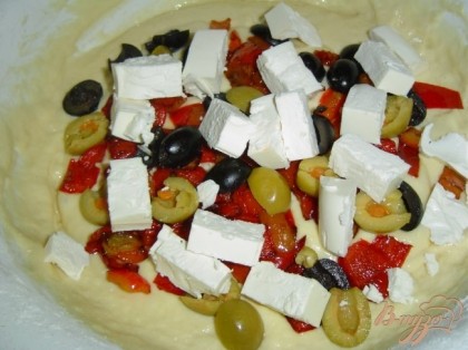 В тесто добавляем остывший перец, нарезанную кубиками фету, разрезанные пополам маслины и оливки.