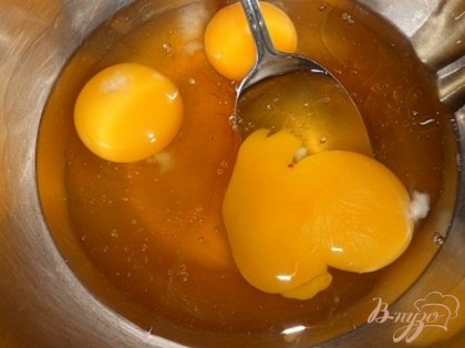 В мисочку вбить яйца и добавить к ним мед.