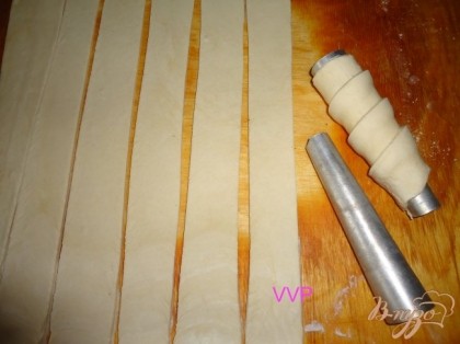 Холодное тесто раскатать тонко и нарезать на полоски.Каждую полоску намотать на трубочку.