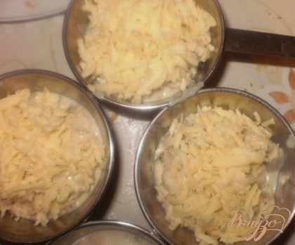 Сверху посыпаем тертым сыром. Ставим кокотницы в духовку разогретую до 180 градусов и запекаем до румяной сырной корочки.